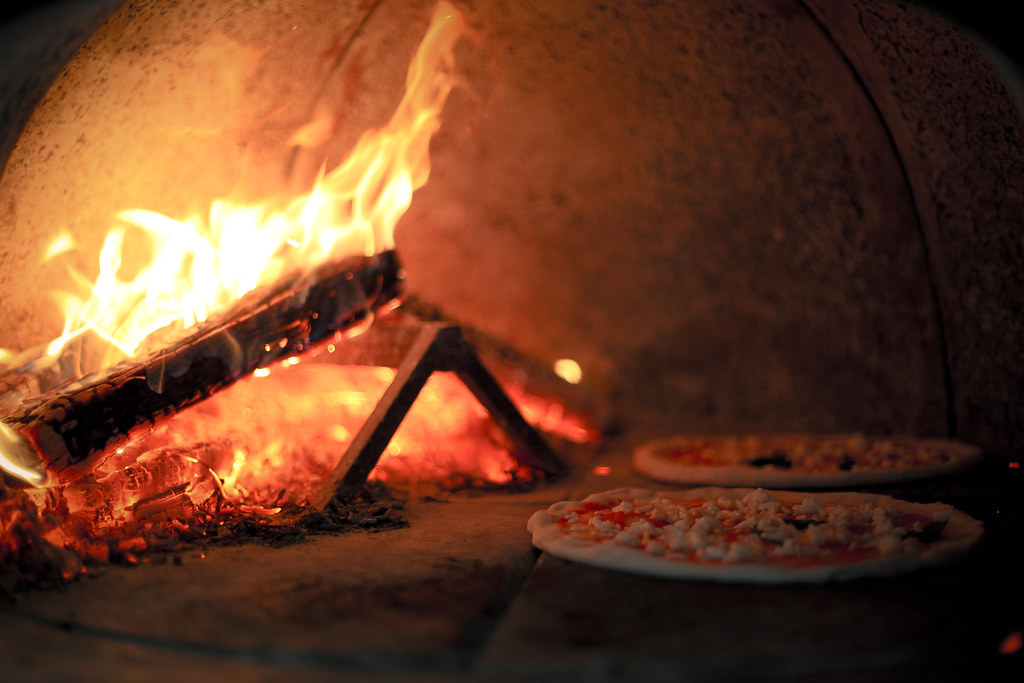 Authentic brick oven with roaring fire for artisan pizza cooking